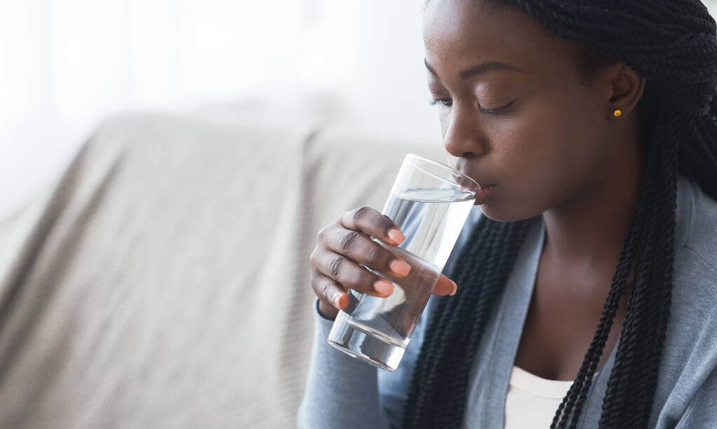 woman drinking clean water from glass at home